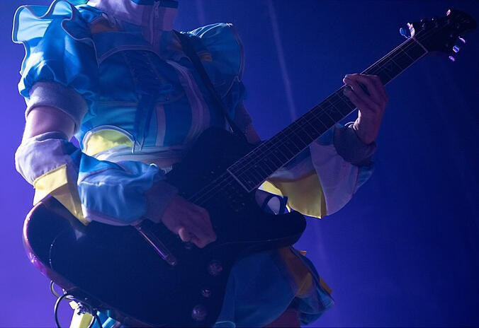 Ritsu playing the guitar from the official concert photos